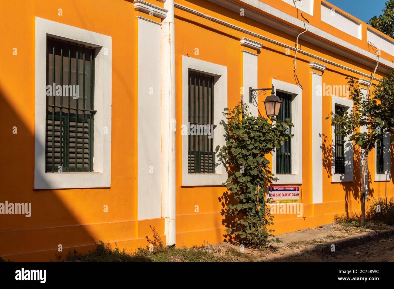 Pondicherry. India - February 2020: Old French era houses painted in bright yellow orange colors on a quiet street in the old town. Stock Photo