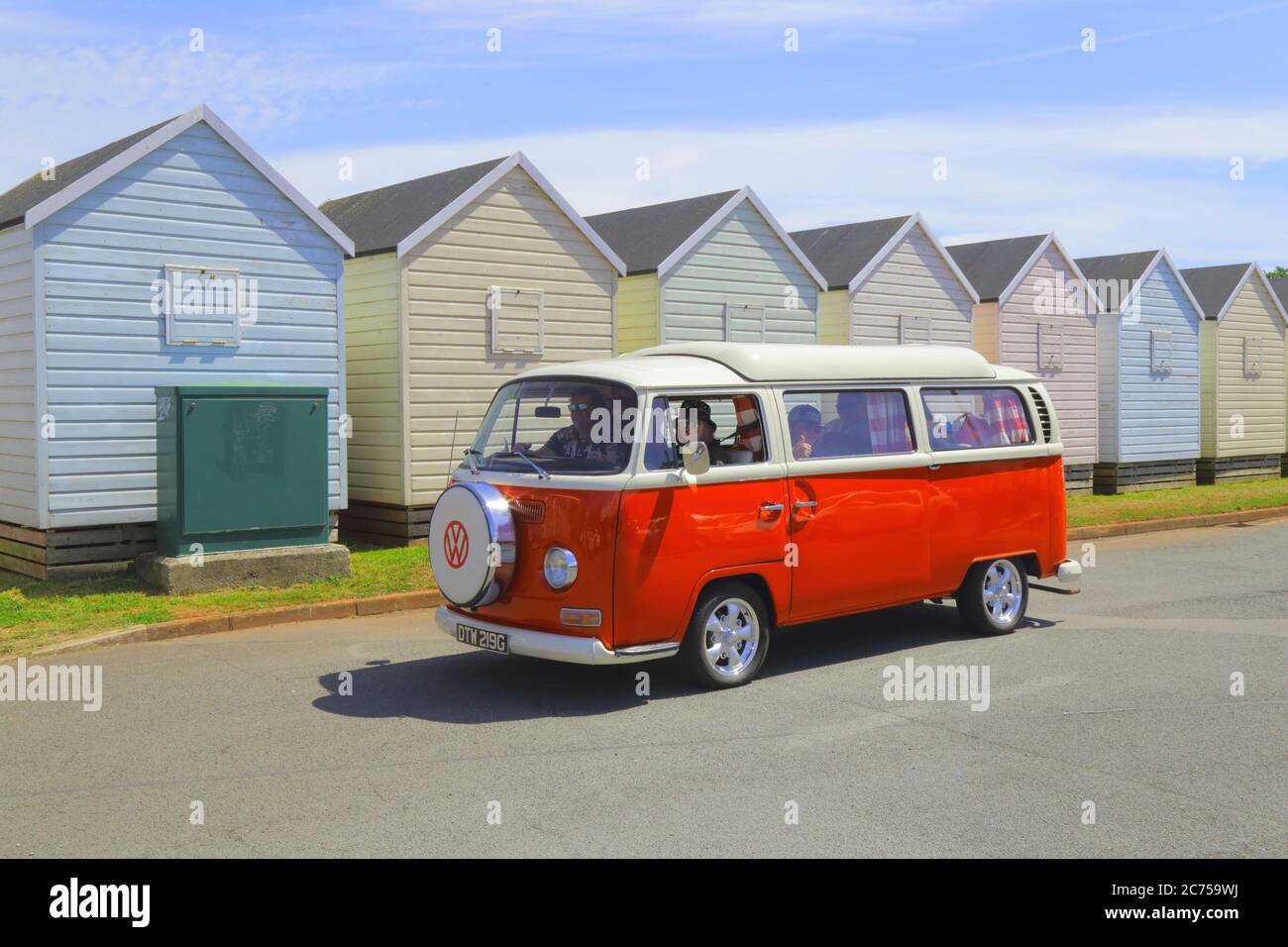 Classic Volkswagen camper van with beach huts in background near Broadsands Beach, Devon Stock Photo