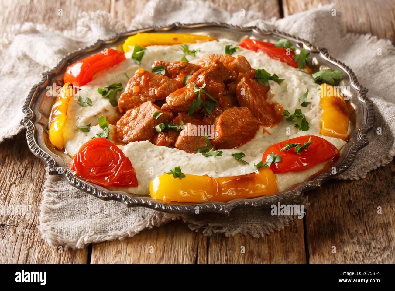 Turkish lamb AliNazik kebab in red sauce with aubergine puree closeup in the plate on the table. Horizontal Stock Photo