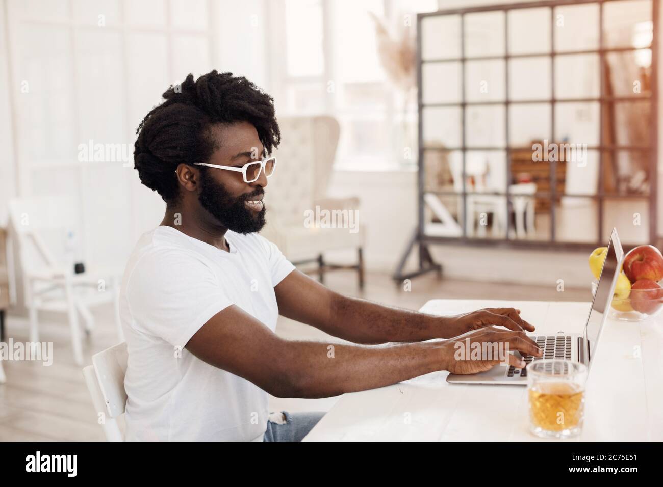 Young black man working at home with laptop Stock Photo