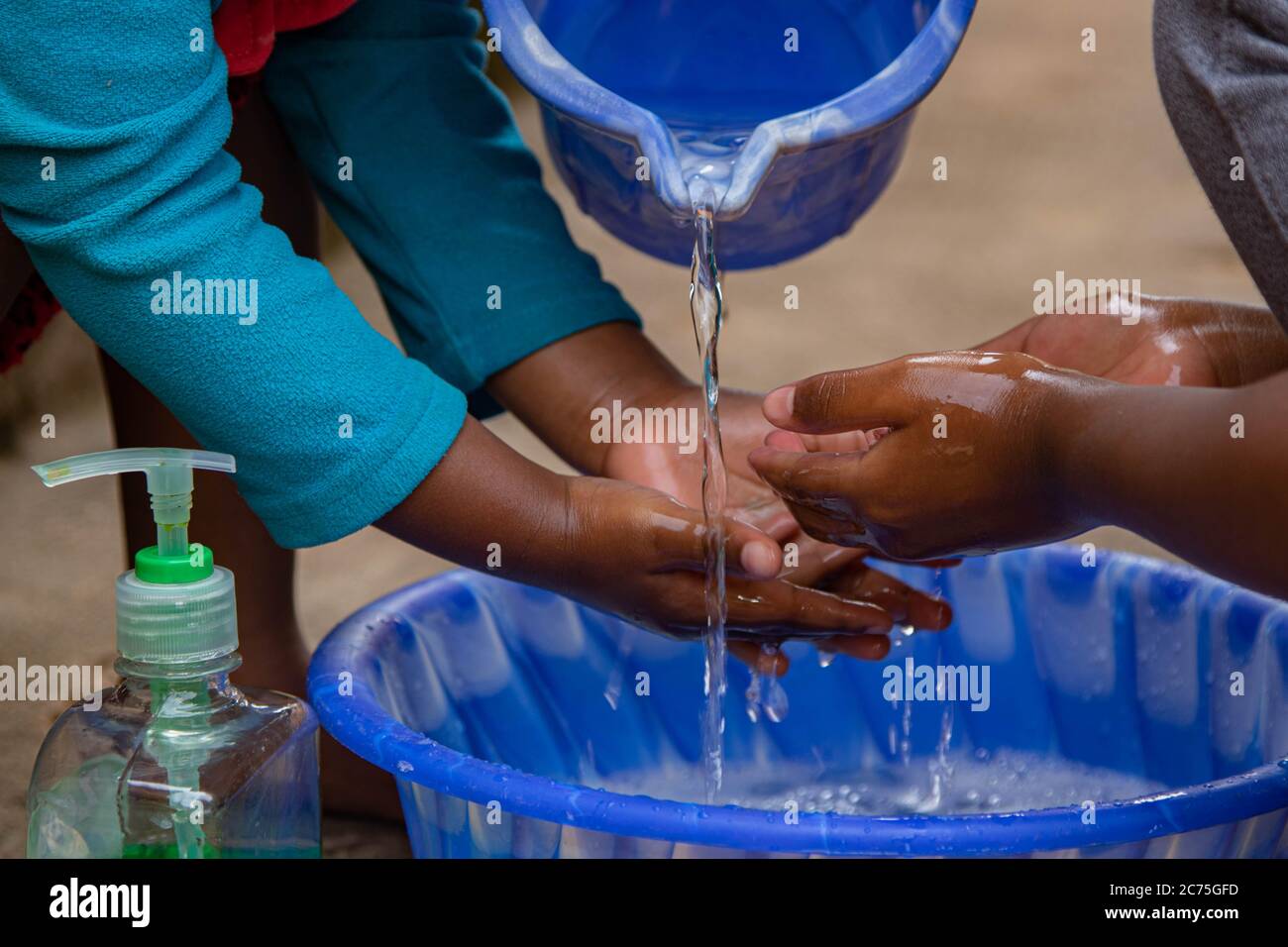 Uwitonze Barbie and Amilia washing their hands with liquid soap. They know this is not only for coronavirus, it is a normal routine before eating anything. It is a part of hygiene at home.  Karugira, Kigali, Rwanda. Stock Photo
