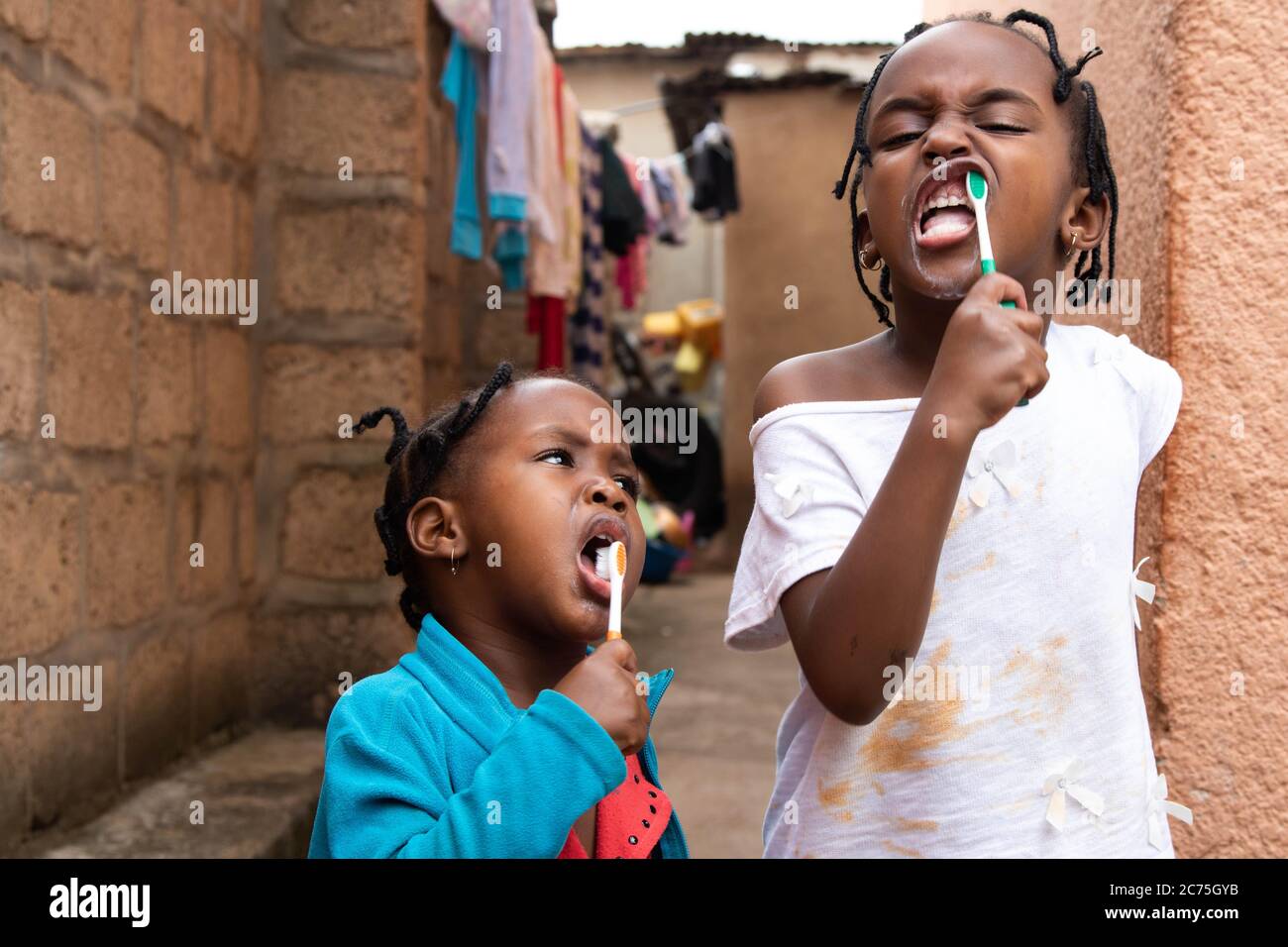 Barbie and Amilia brushing their teeth before having their breakfast. Kids are home due to the Coronavirus. Karugira, Kigali, Rwanda. Stock Photo