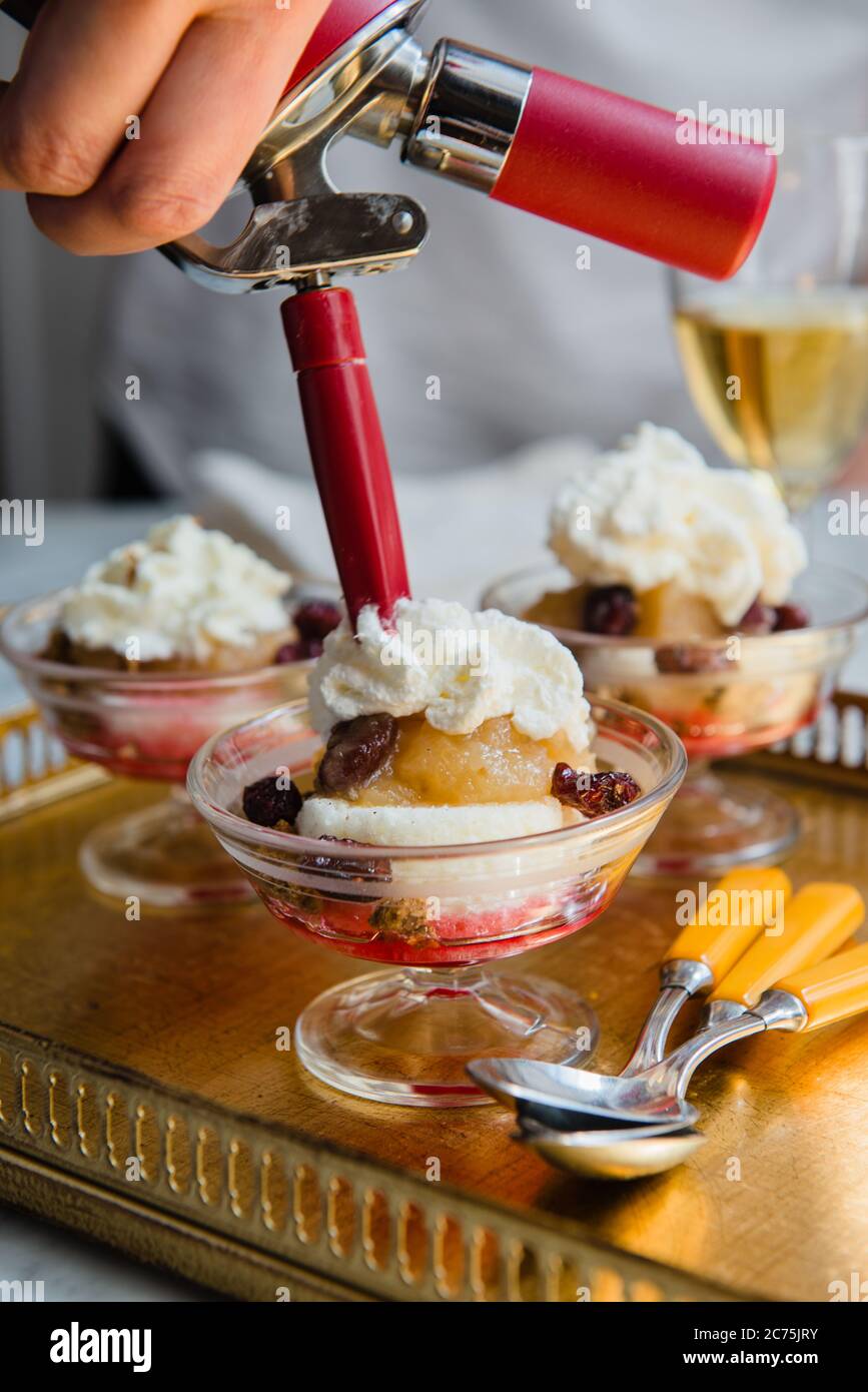 Dessert with fruit and whipped cream being prepared Stock Photo