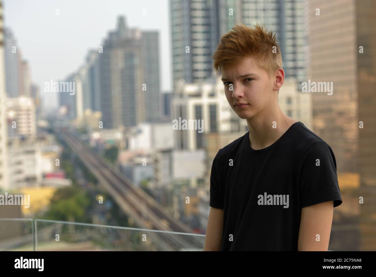 Young handsome teenage boy against view of the city outdoors Stock ...