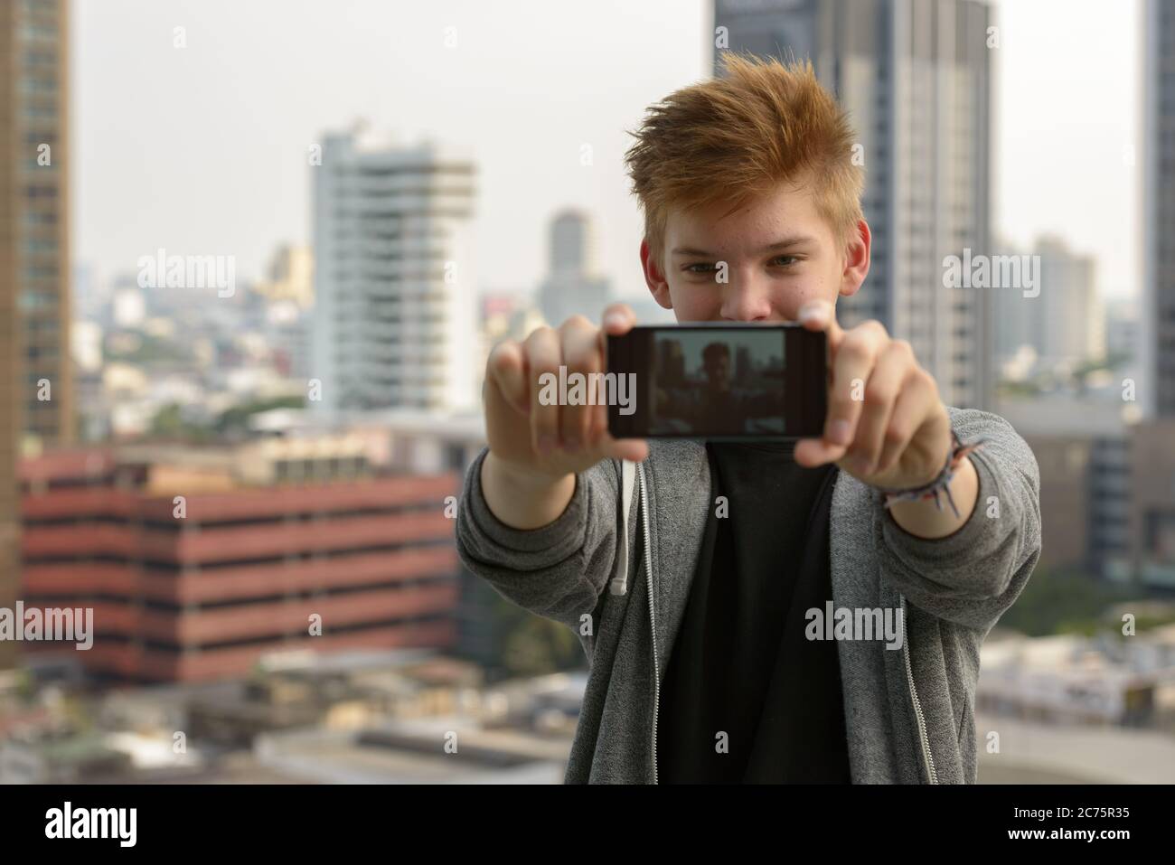 Young handsome teenage boy against view of the city outdoors Stock ...
