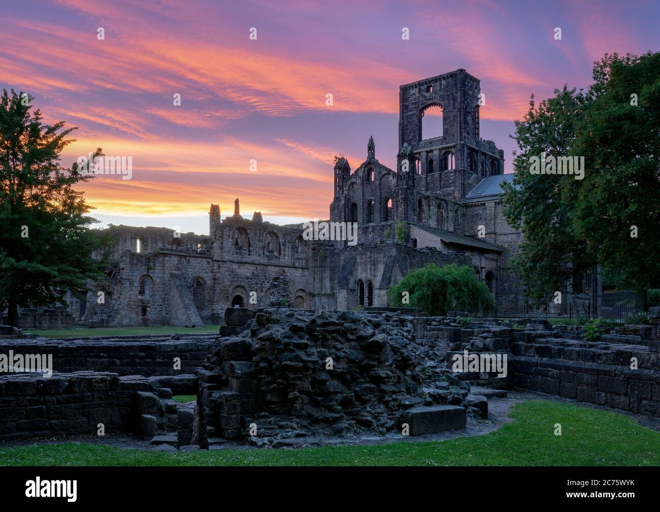 A stunning sunset lights up the sky behind the ruins of Kirkstall Abbey, Leeds (West Yorkshire) on a beautiful summer evening. Stock Photo