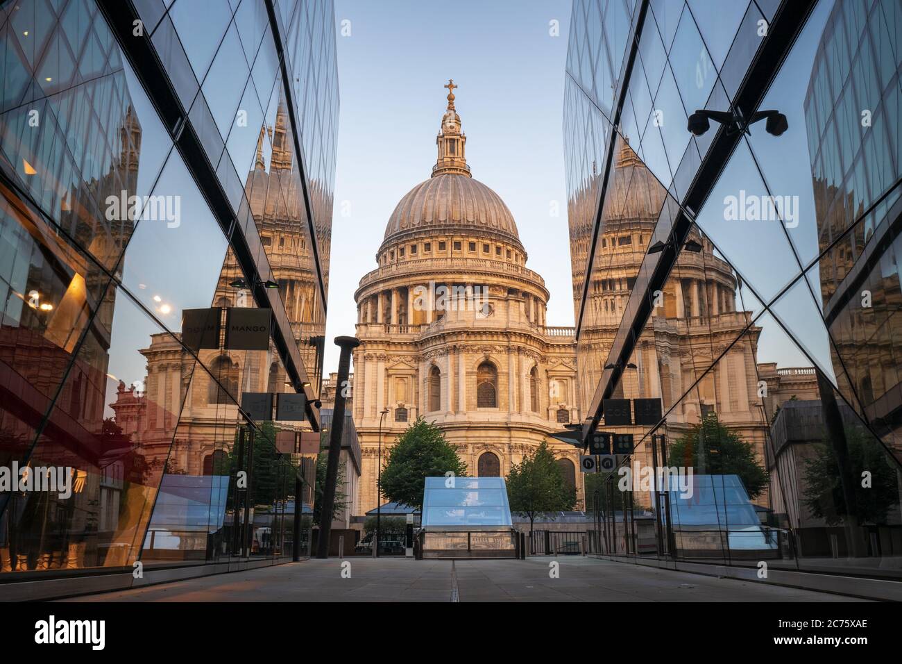 St Pauls Cathedral is reflected in the windows of One New Change on a clear morning, a juxtaposition of traditional and modern in Central London. Stock Photo