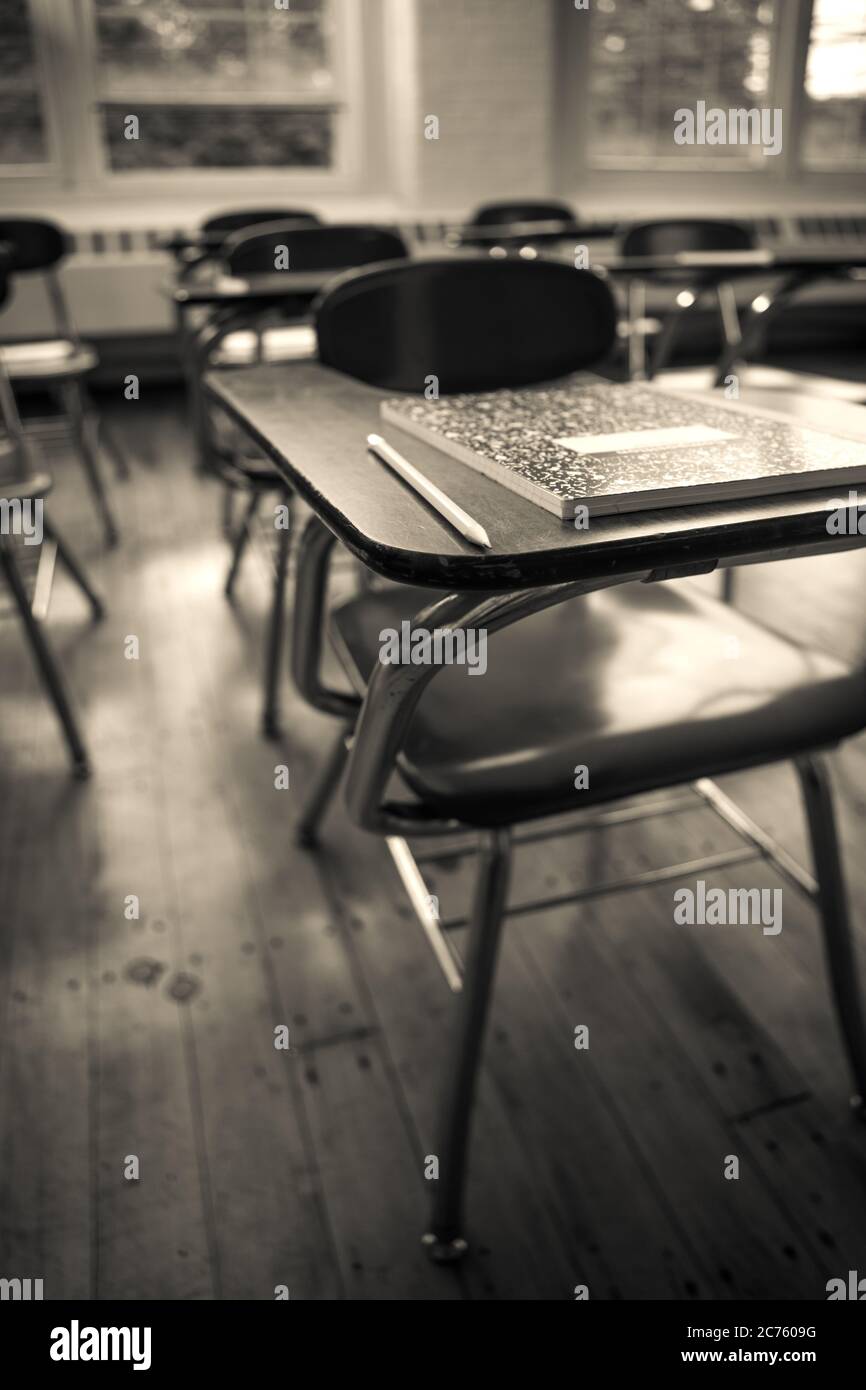 A notebook and pencil on a desk in an old classroom Stock Photo