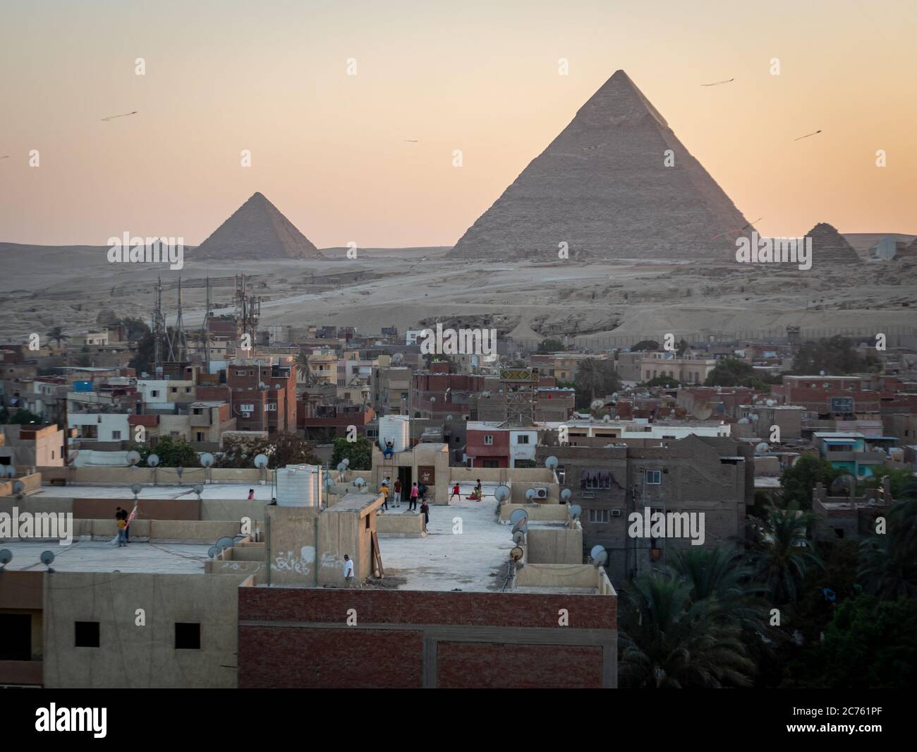 Pyramids view at sunset from giza rooftop with children playing Stock ...