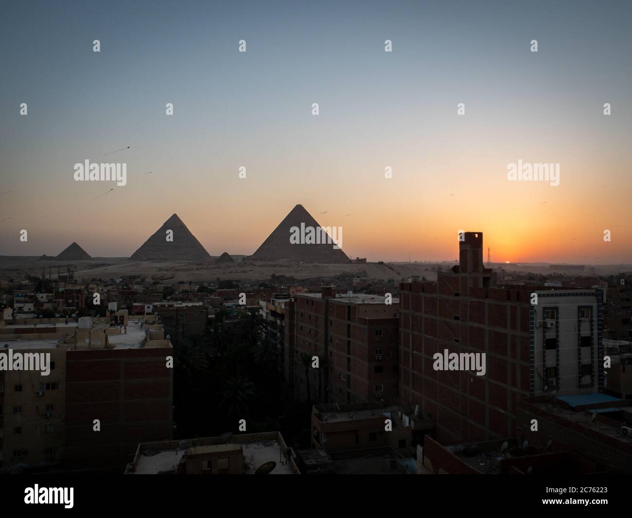 Pyramids view at sunset from giza rooftop with skyline Stock Photo - Alamy
