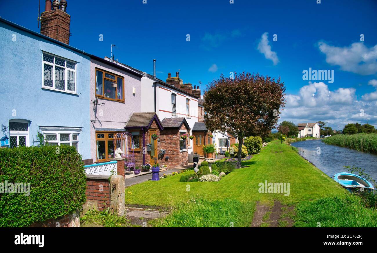 The colourful terrace of New Lane Cottages next to the Leeds to Liverpool Canal in Burscough, Lancashire Stock Photo