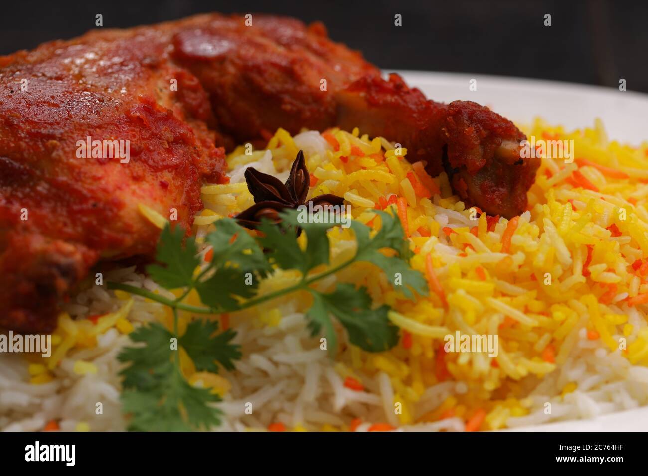 Closeup image of Chicken biryani , Tandoori chicken leg with basmathi rice  and raita or raitha as side dish arranged in a white plate with black Stock  Photo - Alamy