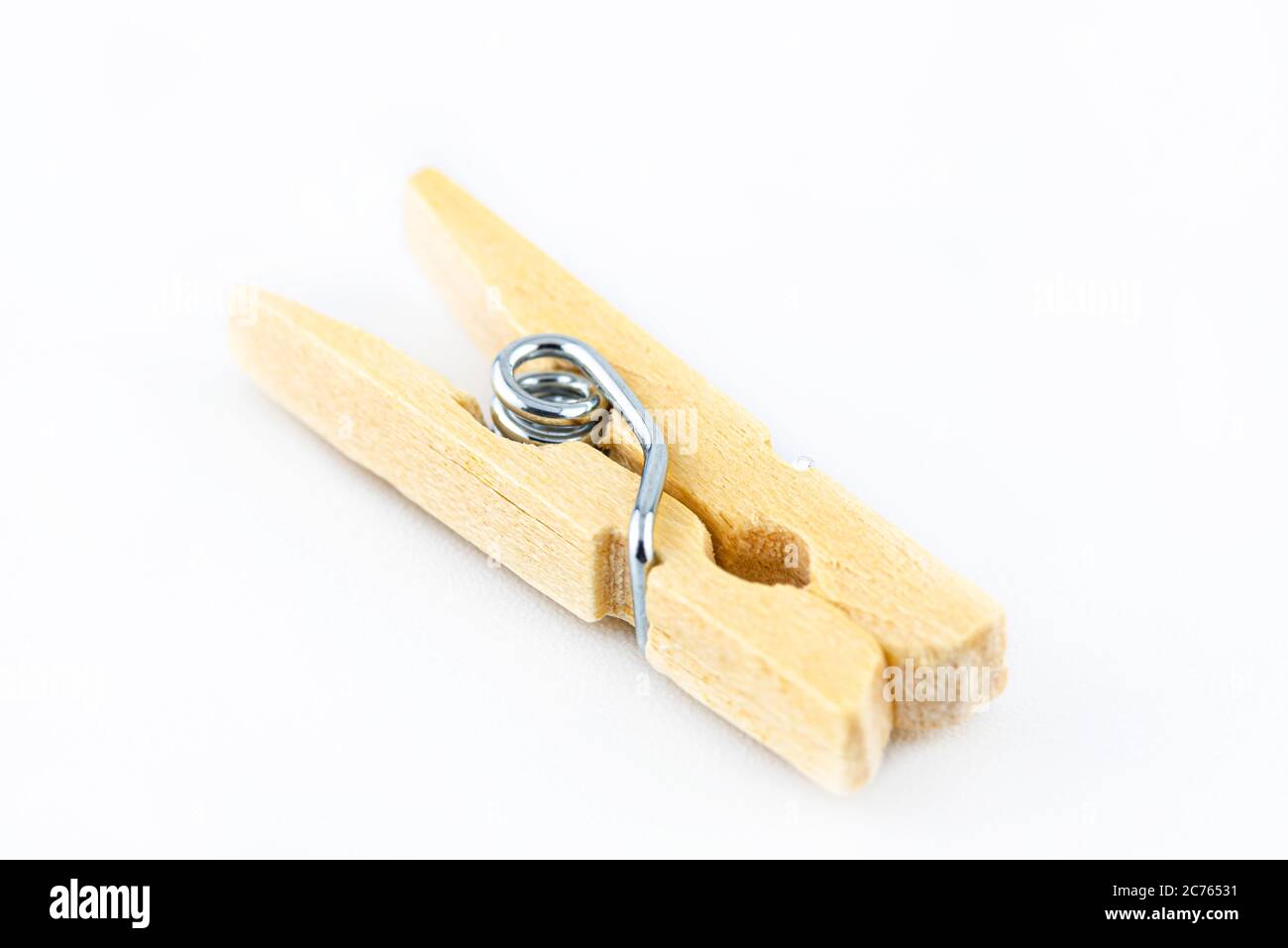 Macro shot of one miniature, wooden clamps lying on a white background. Stock Photo