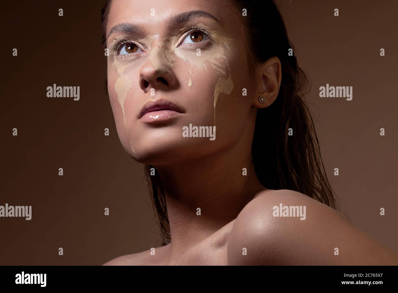 Concept portrait of a young beautiful girl with face art in the form of a map of the world. Light spots on tanned skin, the world with tears. Stock Photo