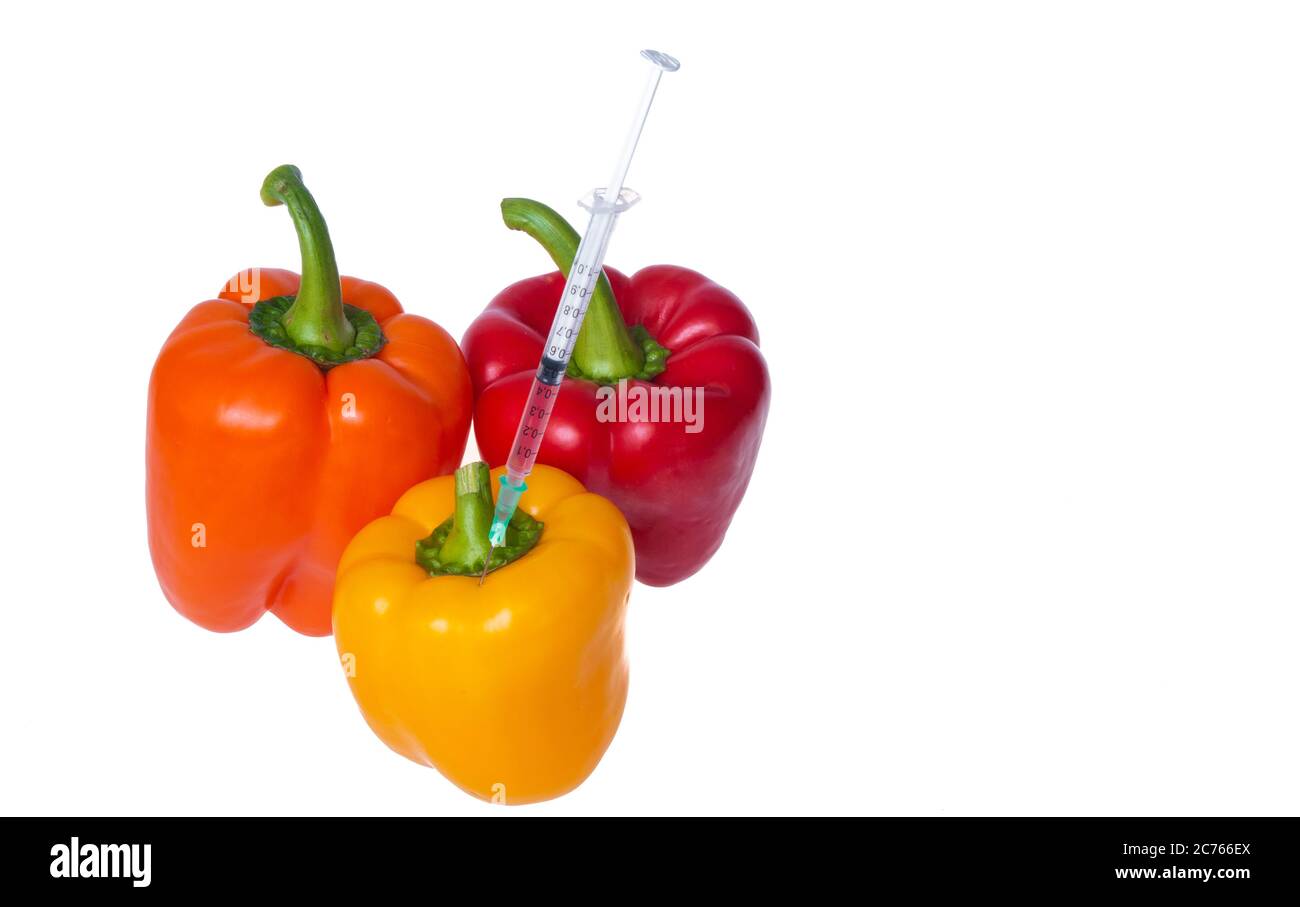 Genetically modified vegetables. GMO food concept. Syringes are stuck in vegetables with chemical additives. Injections into fruits and vegetables. Is Stock Photo