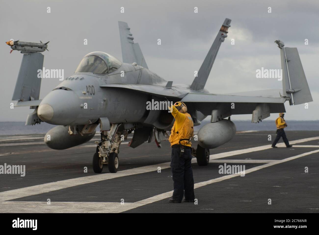A U.S. Marine Corps F/A-18C Super Hornet assigned to the Death Rattlers of Marine Fighter Attack Squadron 323, is positioned on the flight deck of the Nimitz-class aircraft carrier USS Nimitz during dual-carrier operations with the USS Ronald Reagan June 28, 2020 in the Philippine Sea. Stock Photo