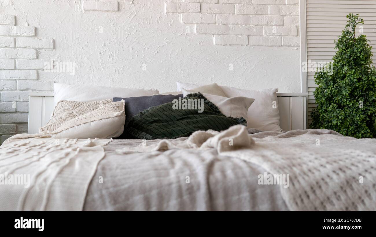 Unmade bed in modern bedroom. From above warm blanket and soft pillows placed on comfortable unmade bed in stylish contemporary bedroom Stock Photo