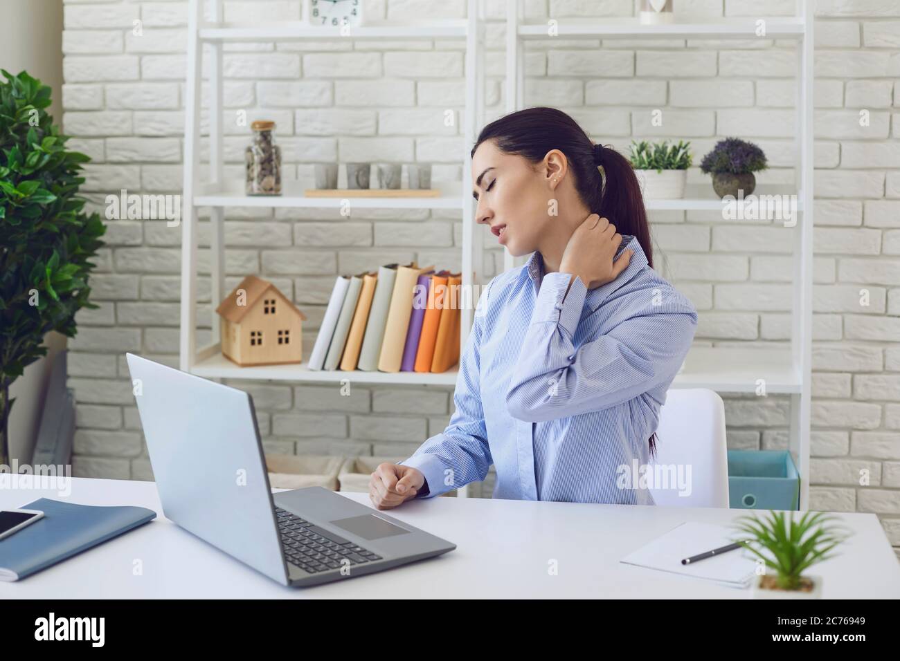 Pain in the neck. Office work. Overworked young woman suffering from