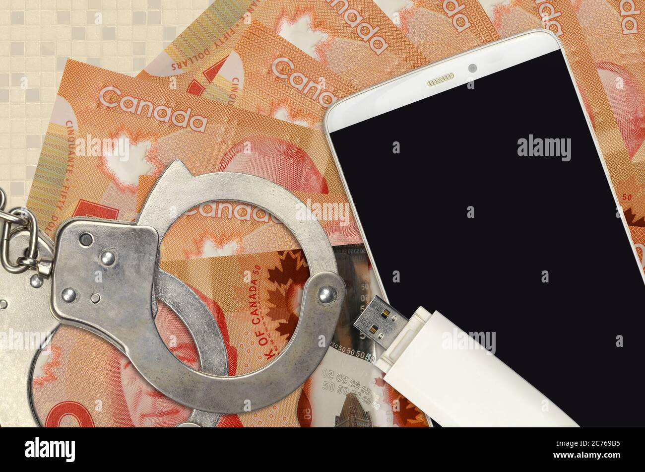 50 Canadian dollars bills and smartphone with police handcuffs. Concept