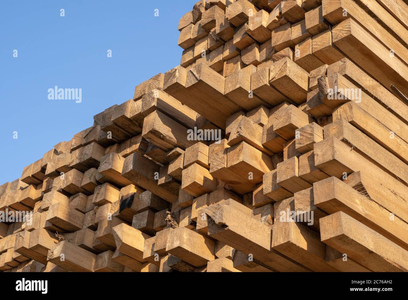 Wooden boards, lumber, industrial wood, timber. Pine wood timber stack of natural rough wooden boards on building site. Industrial timber building Stock Photo