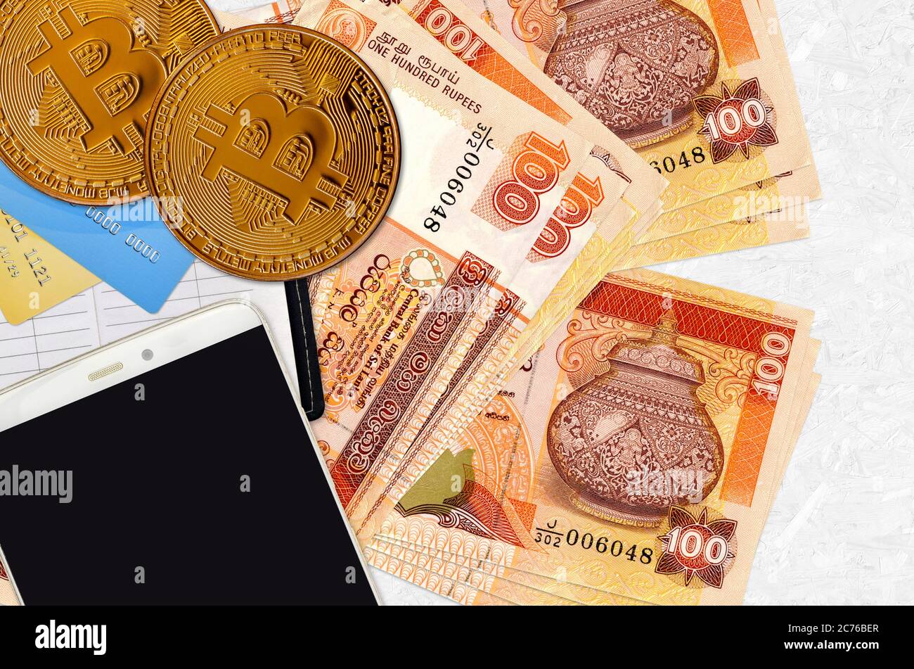 100 Sri Lankan rupees bills and golden bitcoins with smartphone and credit  cards. Cryptocurrency investment concept. Crypto mining or trading transact  Stock Photo - Alamy