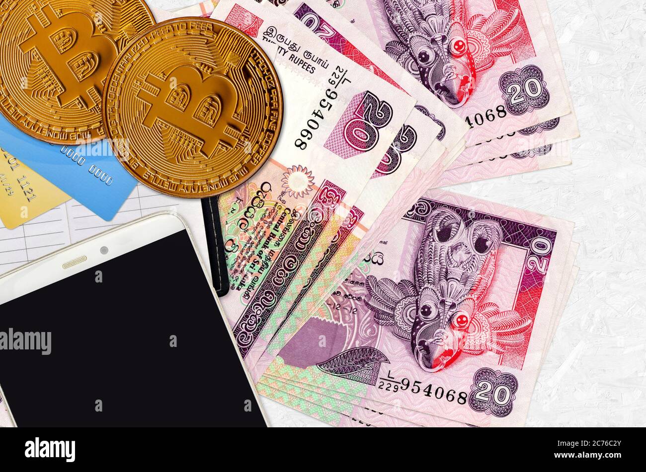 20 Sri Lankan rupees bills and golden bitcoins with smartphone and credit  cards. Cryptocurrency investment concept. Crypto mining or trading  transacti Stock Photo - Alamy