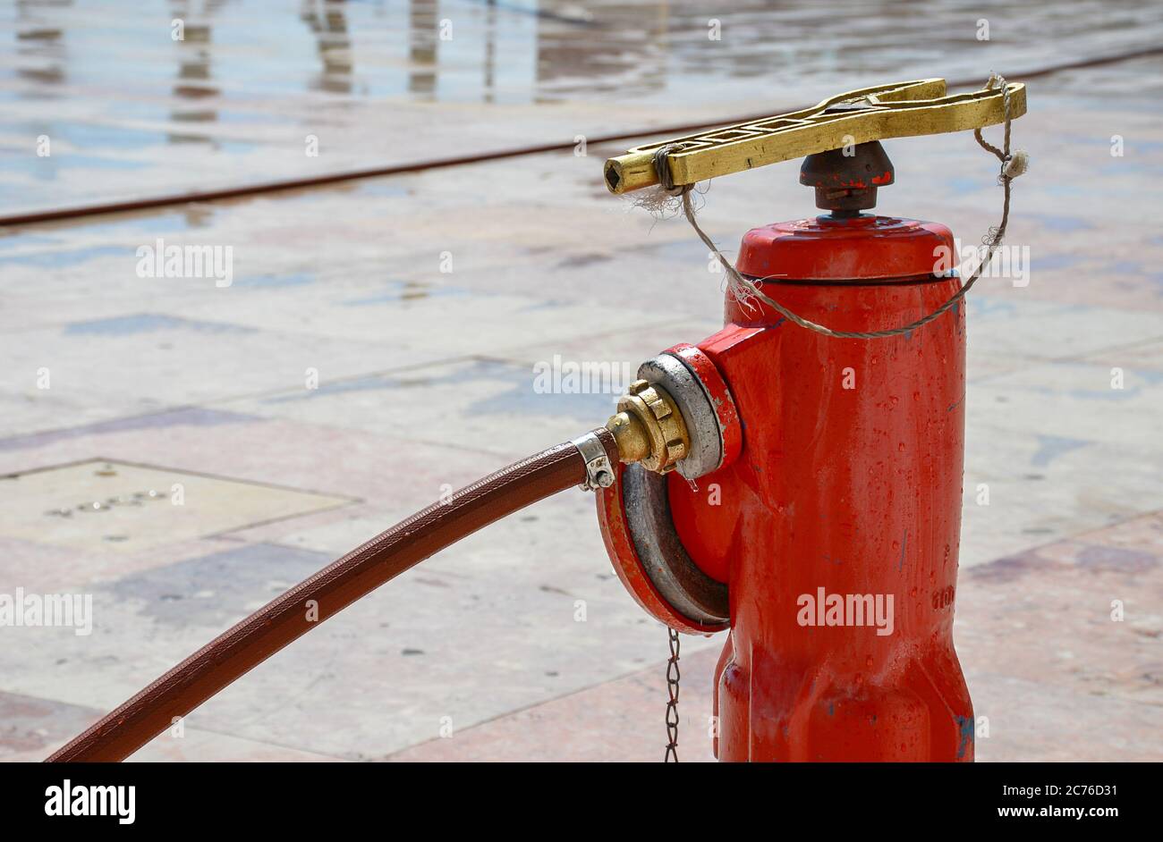 Red fire hydrant on the street for emergency fire access, with key
