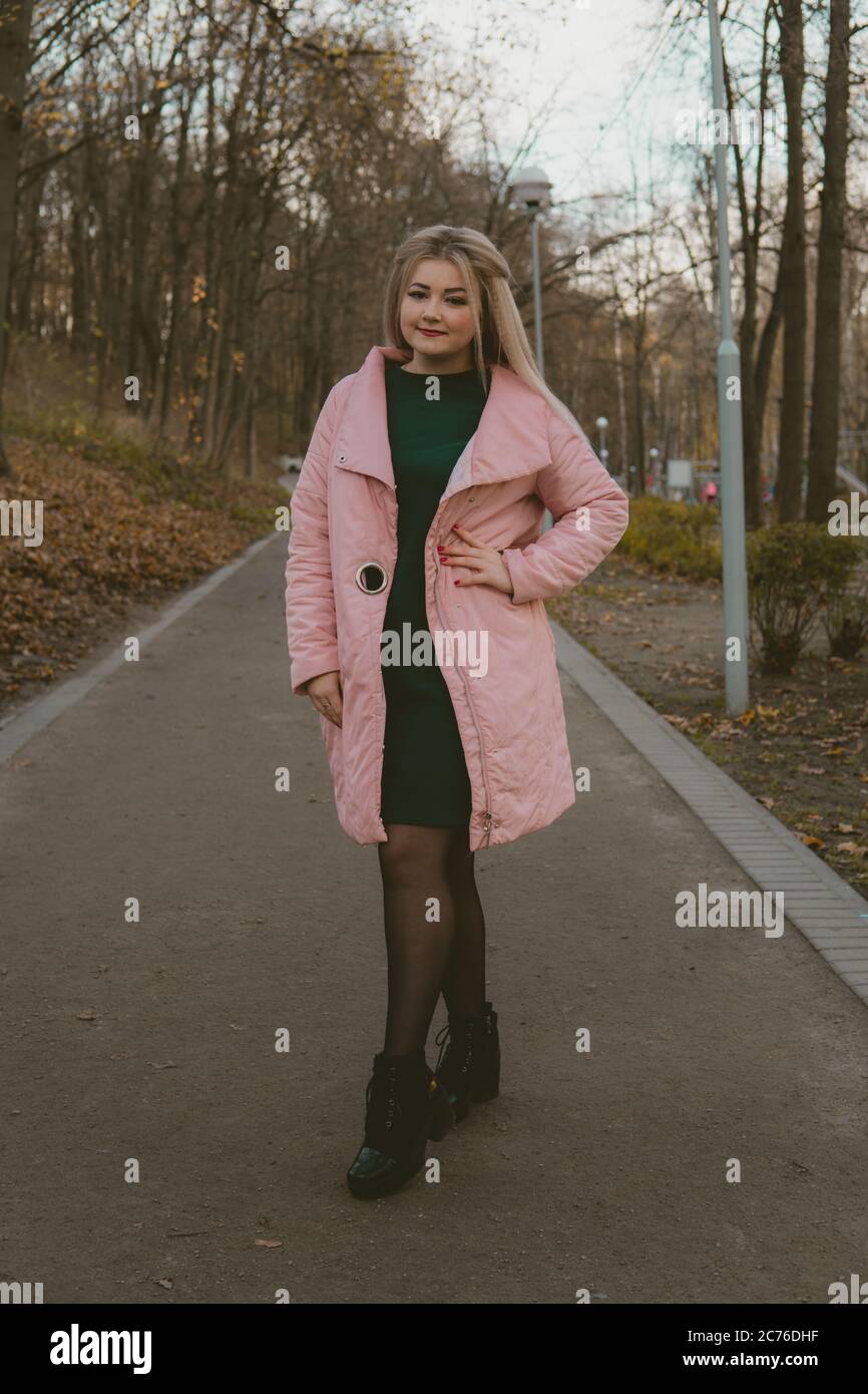 A beautiful girl walks along the alley in the autumn park. Stock Photo