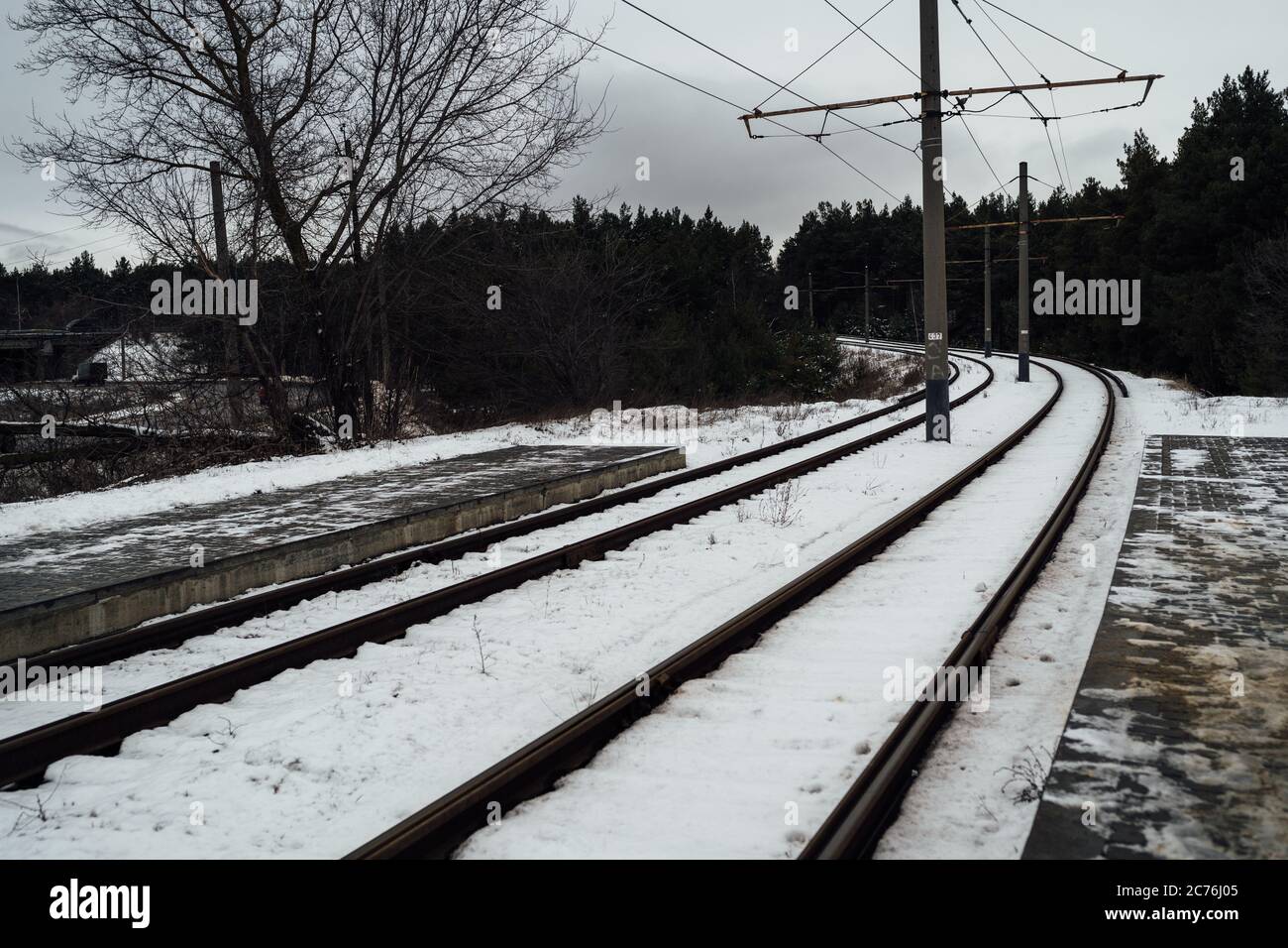 Train rails in winter season. Beautiful landscape of countryside. Rail track laid through forest. Stock Photo