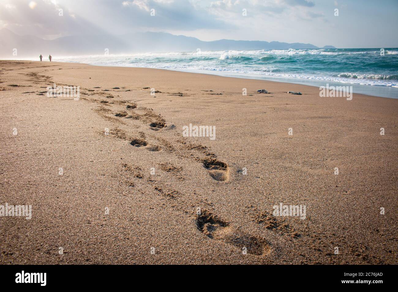 Beautiful beach with footprints in the sand. Couple of lovers walking ...