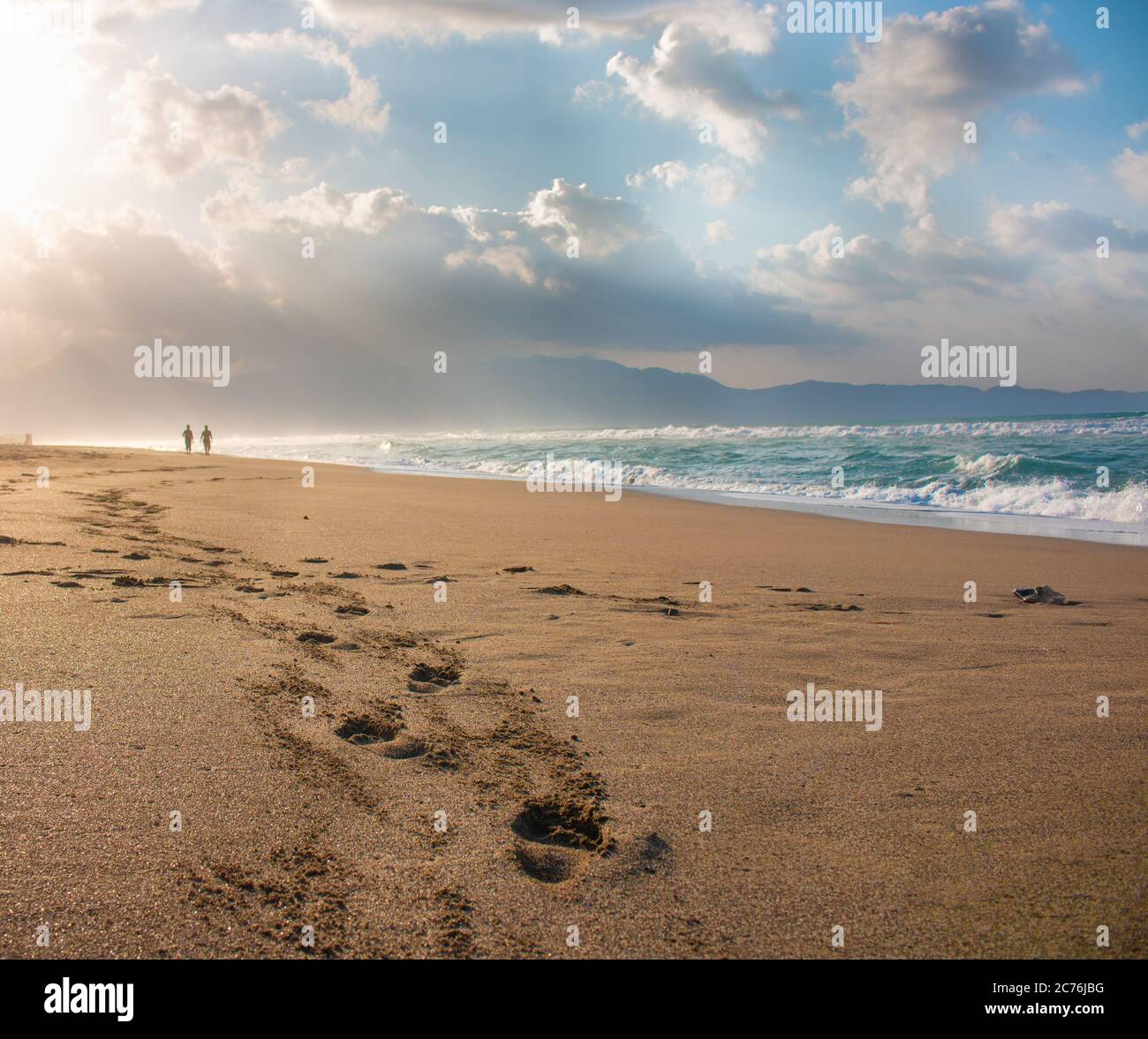 Beautiful beach with footprints in the sand. Couple of lovers walking ...