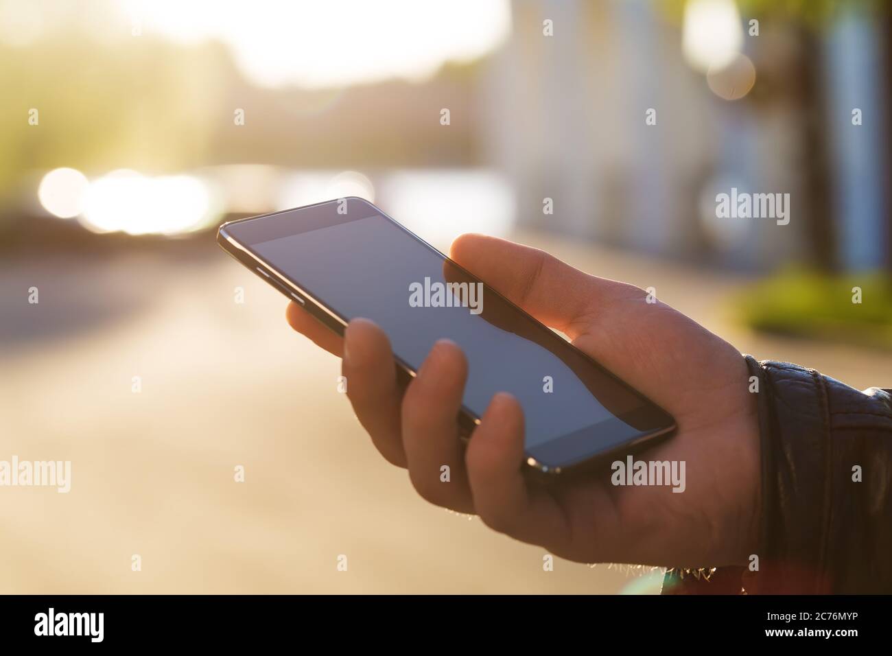 Man using his Mobile Phone outdoor, close up Stock Photo