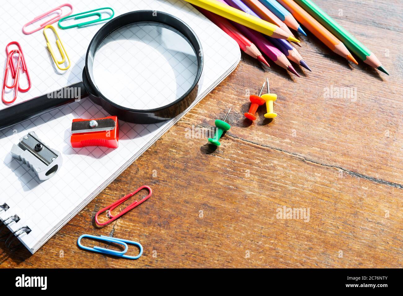 https://c8.alamy.com/comp/2C76NTY/back-to-school-note-book-pencils-loupe-green-apple-on-wooden-table-2C76NTY.jpg