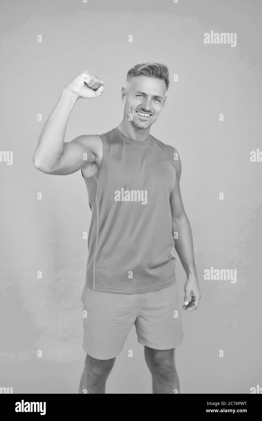 Boost your athletic power. Happy man fix arm blue background. Fit guy show muscle power. Sports clothes and sportwear. Power and strength. Training for power. Fitness and sport. Stock Photo