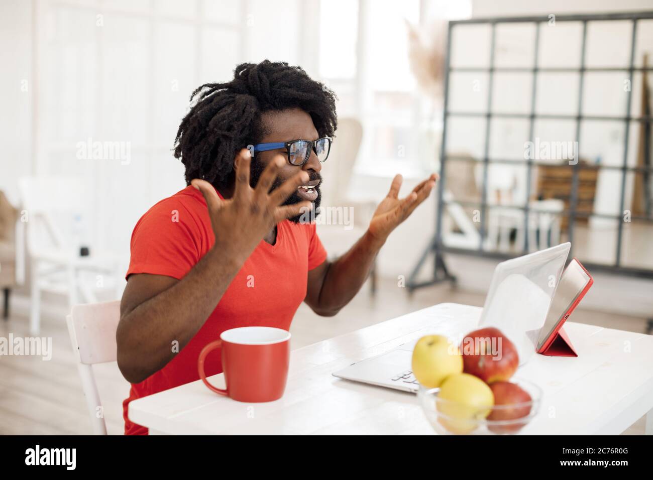 Young black man doing call in zoom at home with laptop Stock Photo