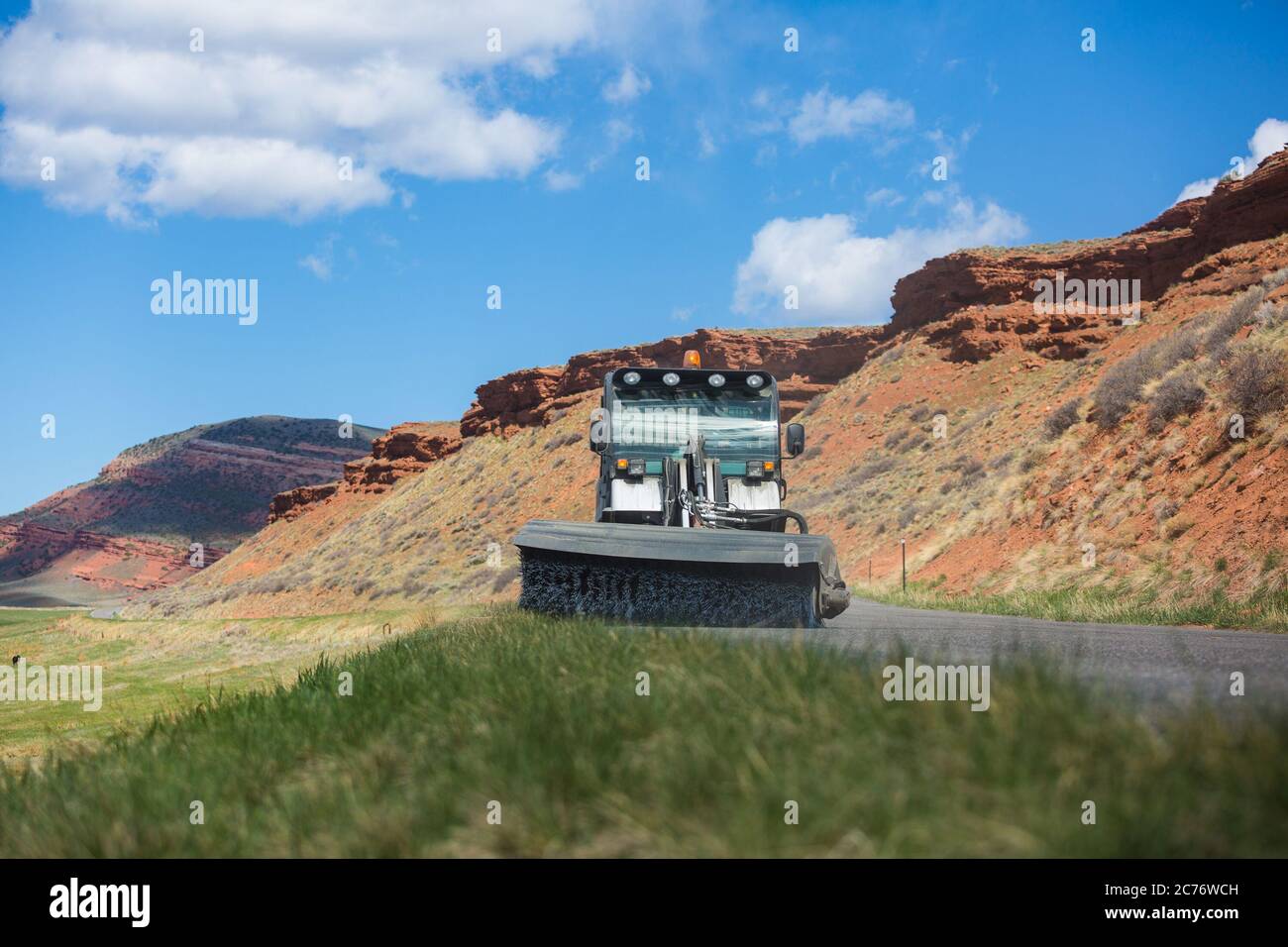 Street sweeper cleaning road in desert landscape, Wyoming, USA Stock Photo