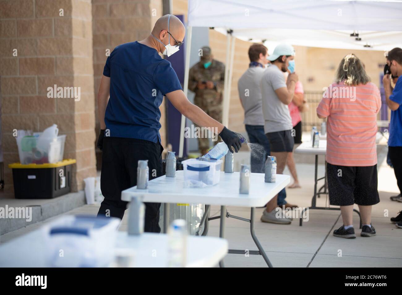 San Marcos, USA. 14th July, 2020. Specialist EZEKIEL THODY of the Texas National Guard wipes down surfaces with disinfectants after helping Hays County residents complete a non-contact test during a free COVID-19 clinic sponsored by the Texas Division of Emergency Management. Texas has seen a huge spike in cases since an early reopening last month and a total of over 3,200 deaths attributed to the virus. Credit: Bob Daemmrich/Alamy Live News Stock Photo