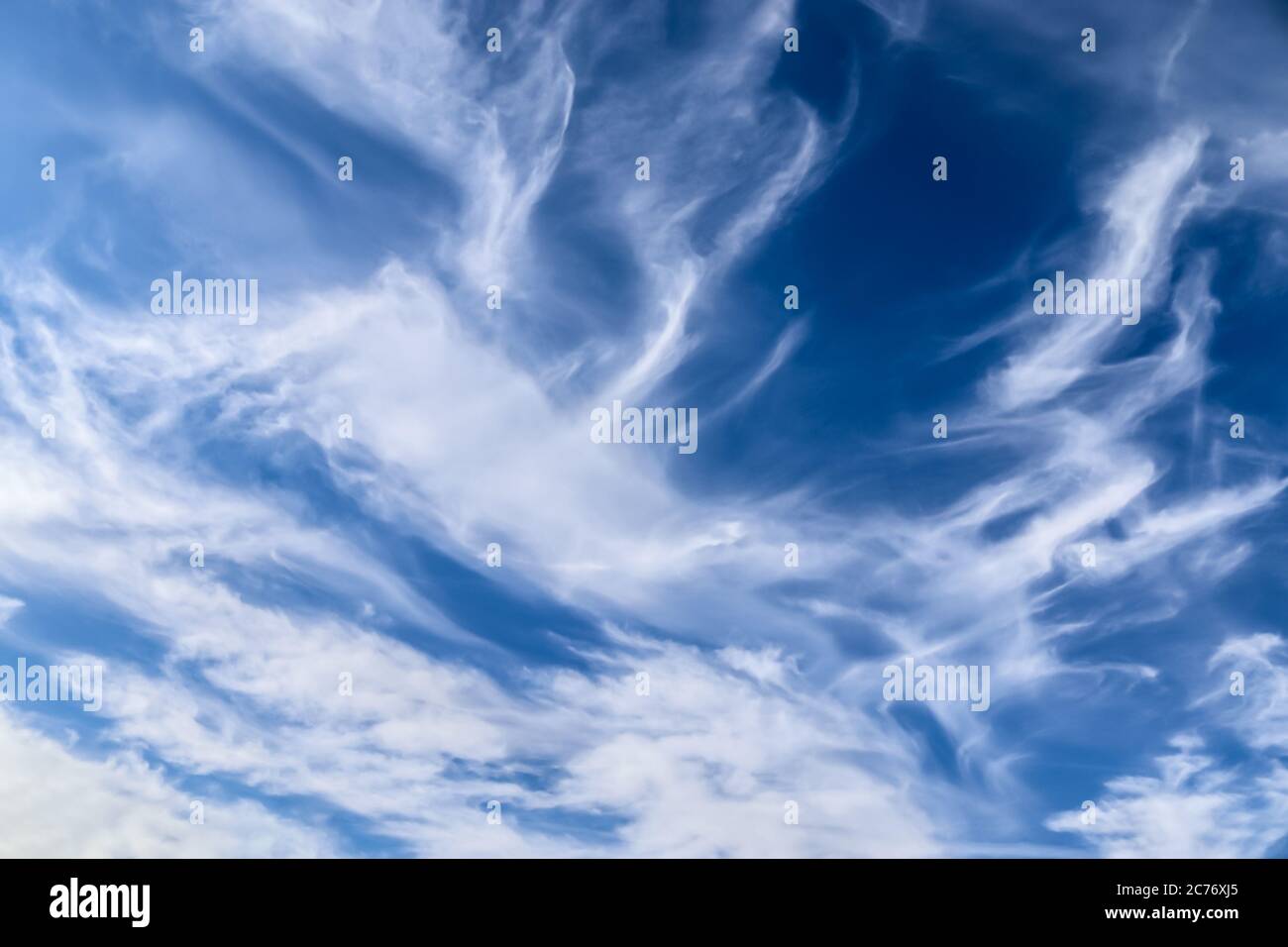 Stunning cirrus cloud formation panorama in a deep blue summer sky seen ...