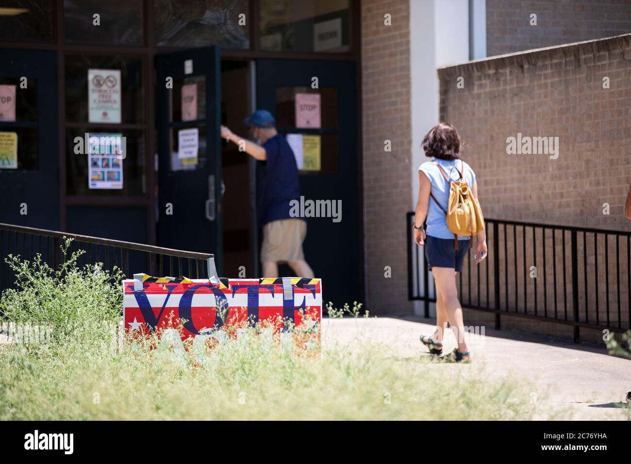 Austin, TX USA July 14, 2020: Masked voters enter polling places in south Austin for the primary runoff election to determine matchups for the November general elections. Heavy by runoff standards, in-person voting is expected to still be less than 10% of registered Texas voters. Credit: Bob Daemmrich/Alamy Live News Stock Photo