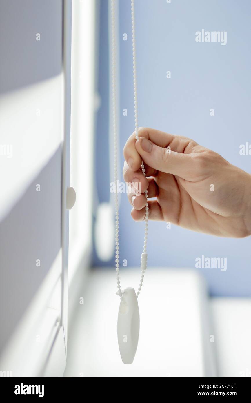 Man testing cassette roller blinds on windows. Stock Photo