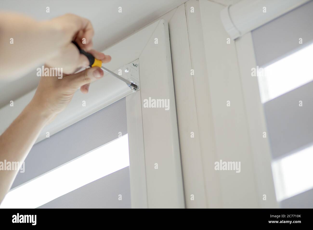 Man installing cassette roller blinds on windows Stock Photo