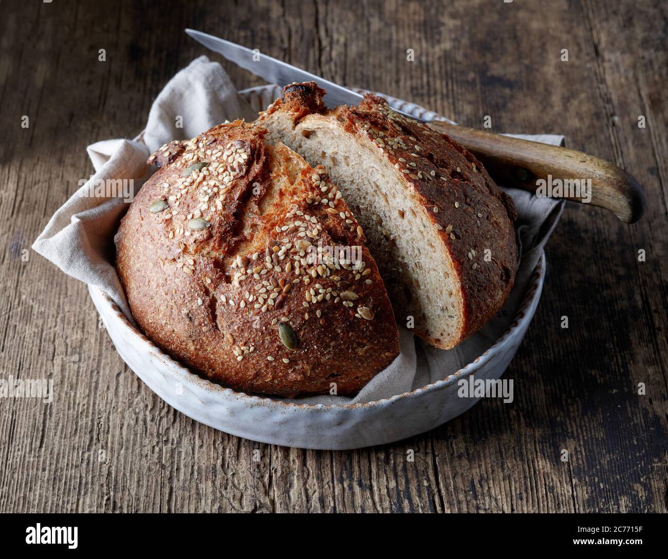 freshly baked artisan bread on rustic wooden kitchen table Stock Photo ...