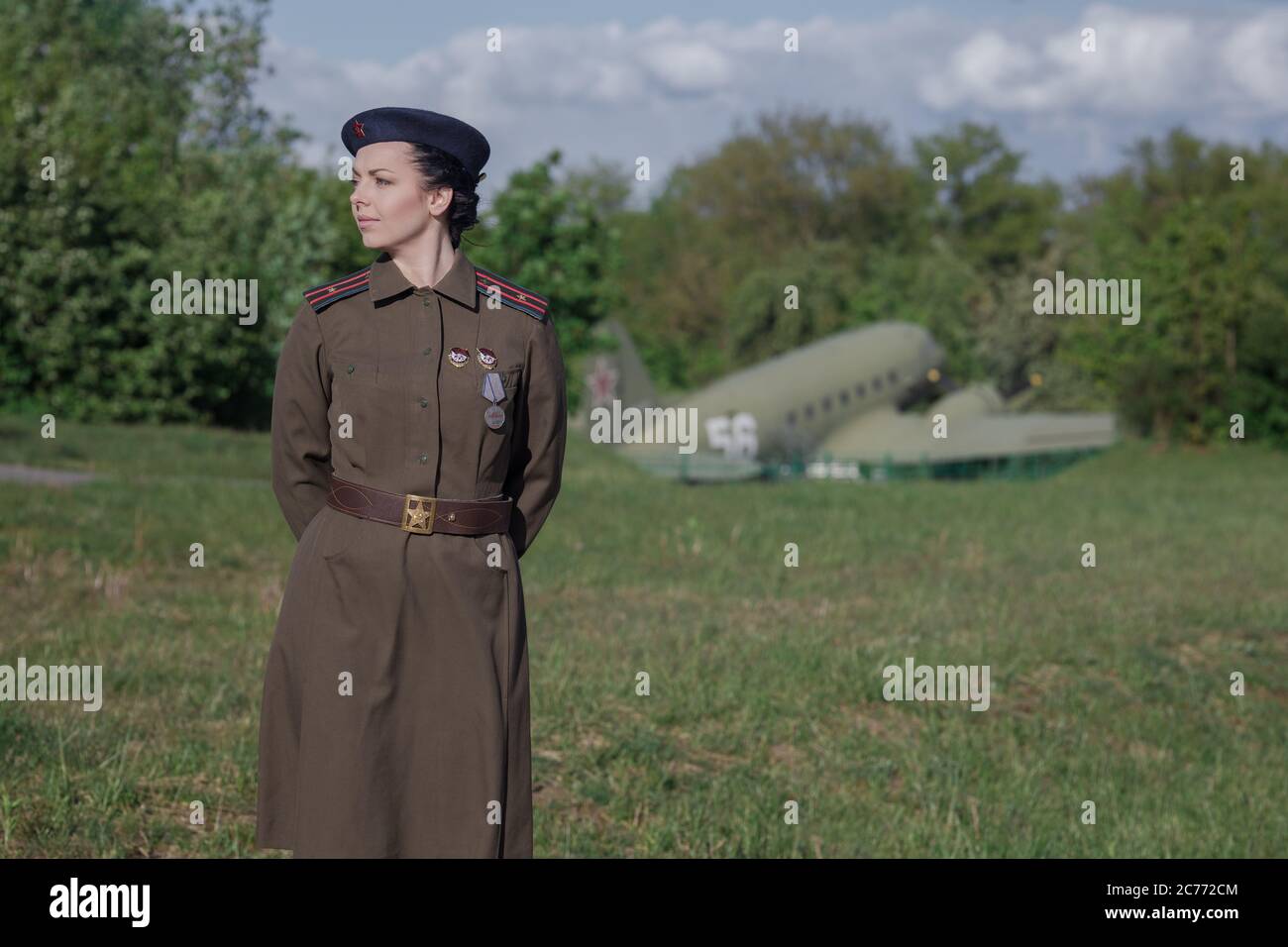 A young female pilot in uniform of Soviet Army pilots during the World War II. Military shirt with shoulder straps of a major and a beret. Against the Stock Photo