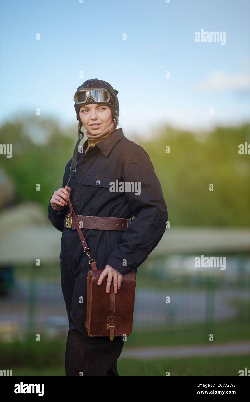 A young female pilot in uniform of Soviet Army pilots during the World War  II. Black flying jumpsuit, helmet and goggles. Photo in retro style Stock  Photo - Alamy