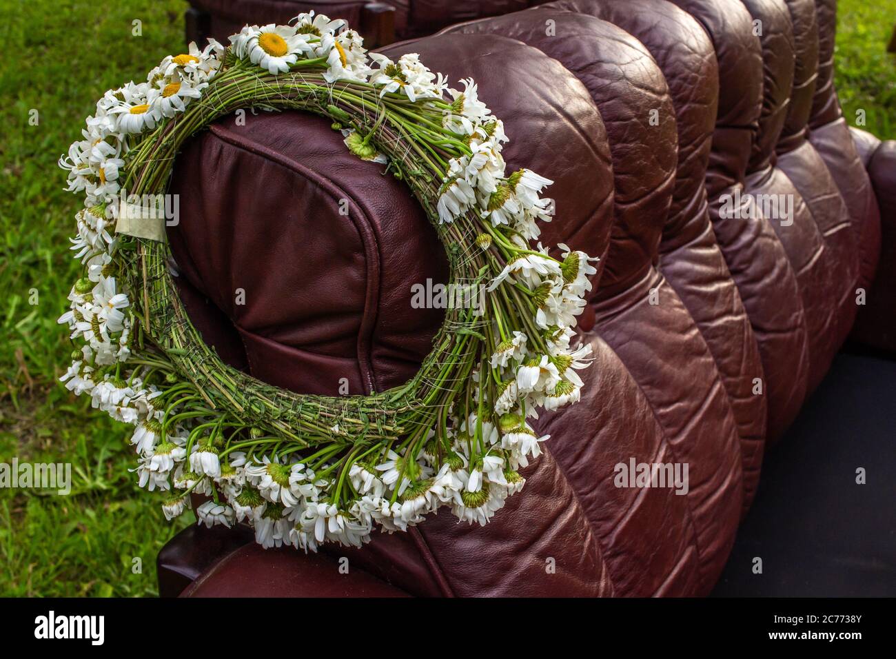 Flower crown on brown sofa, midsummer festival symbol, made of white plants Stock Photo