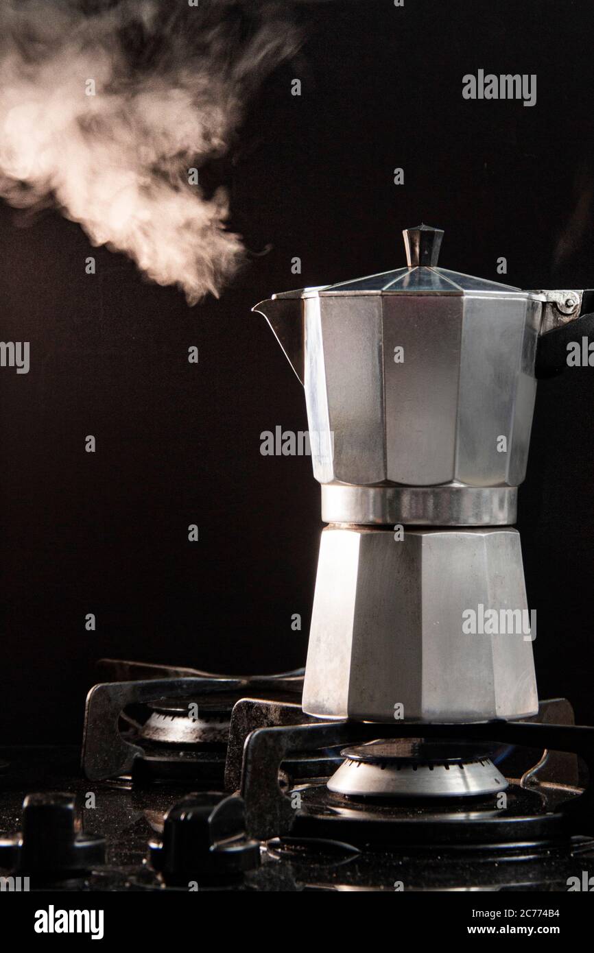 Steaming Moka Pot on a gas stove Stock Photo