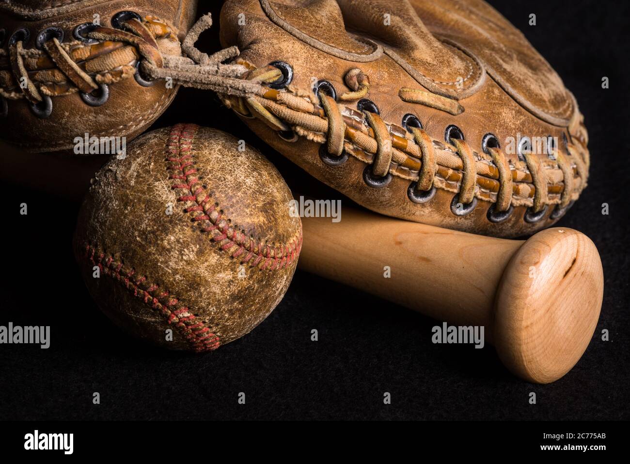 Contrast of old and new equipment with old mitt and ball joined by brand new baseball bat. Stock Photo