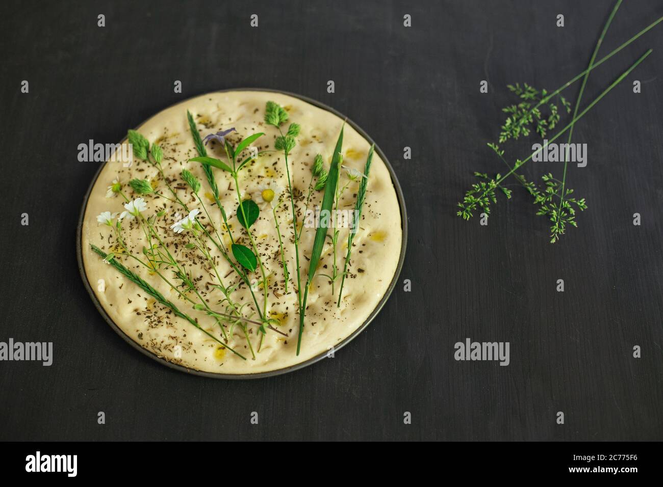 Preparing a garden flatbread with wildflowers, grasses and herbs Stock Photo