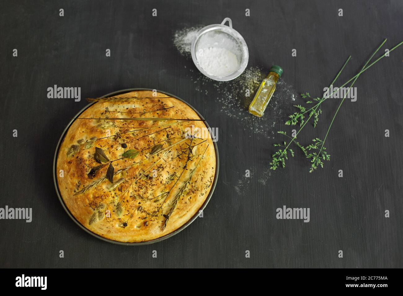 Freshly baked garden flatbread with wildflowers, grasses and herbs Stock Photo