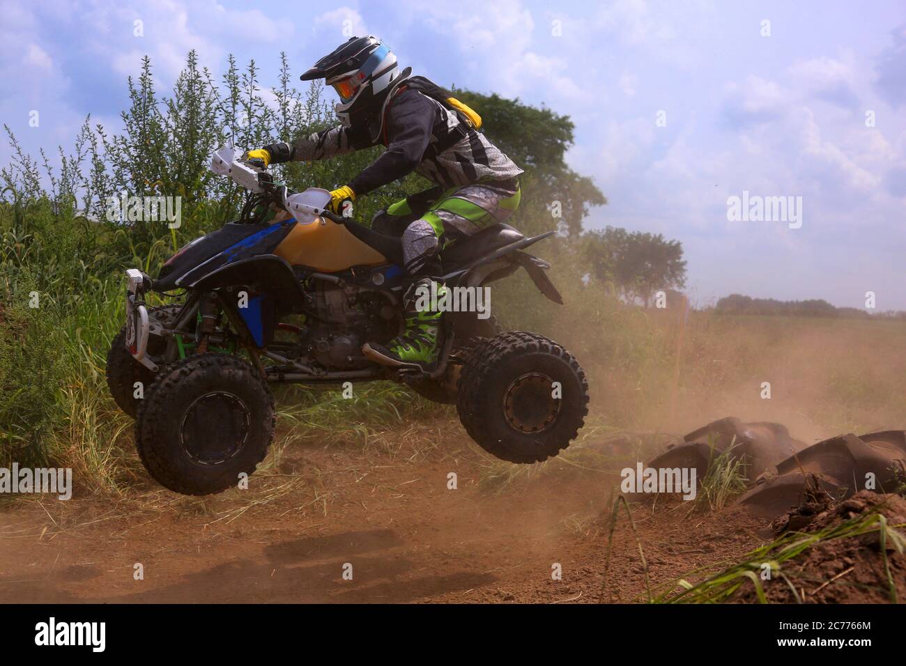 An ATV rider catches some air off of a jump during a weekend ride. Stock Photo
